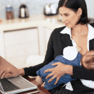 Baby nursing while parent holds baby with one hand and types on a laptop with the other hand