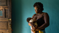 Standing woman breastfeeding at home